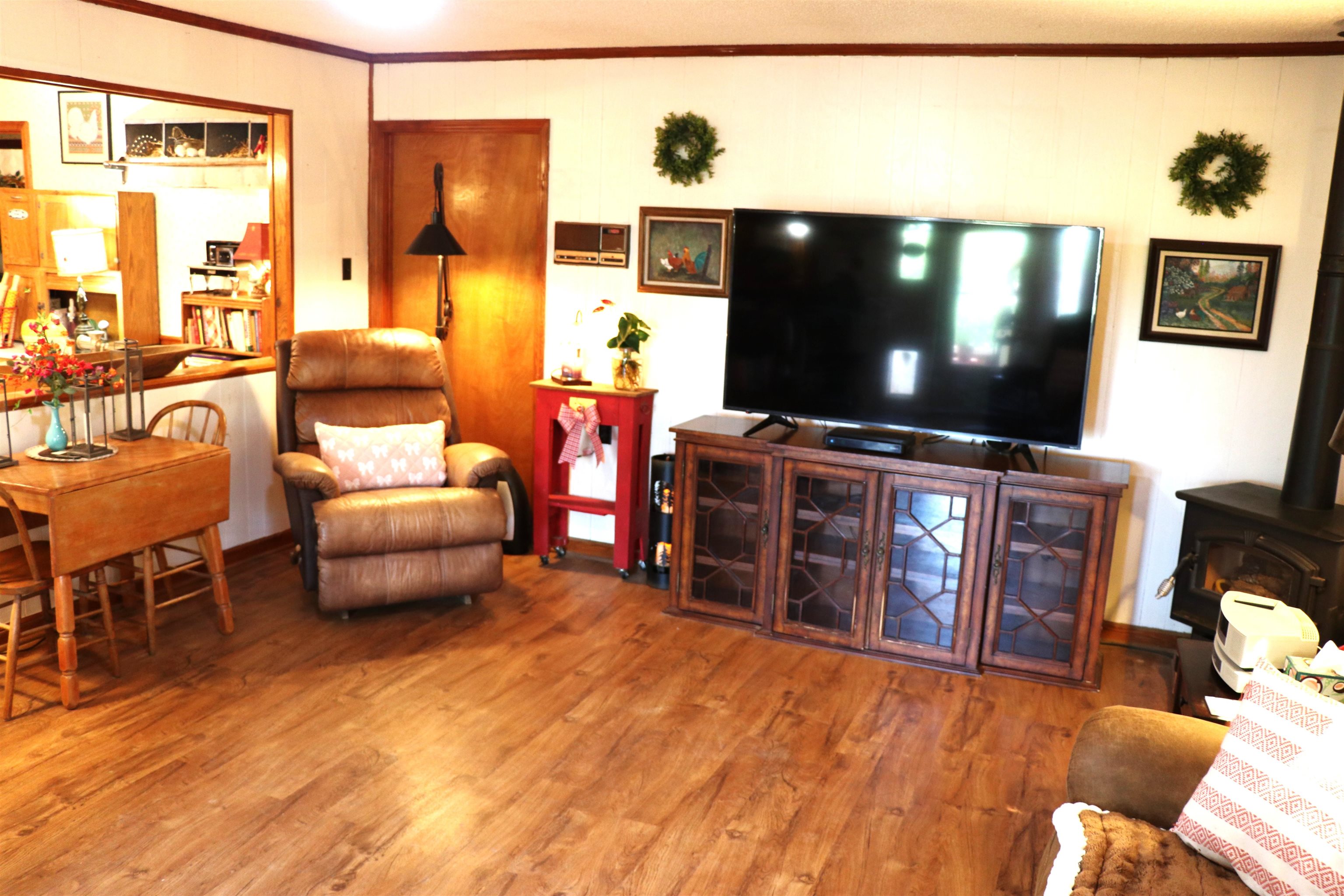 937 Kelleys Chapel Road Burlison, TN 38015 - Photo 7 of 27 Living room with a wood stove, wood finished floors, and ornamental molding
