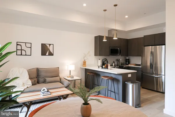 a kitchen with stainless steel appliances granite countertop a refrigerator a sink dishwasher a stove and a refrigerator with wooden floor