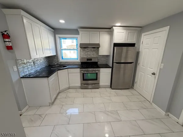 a kitchen with a stove a refrigerator and a sink