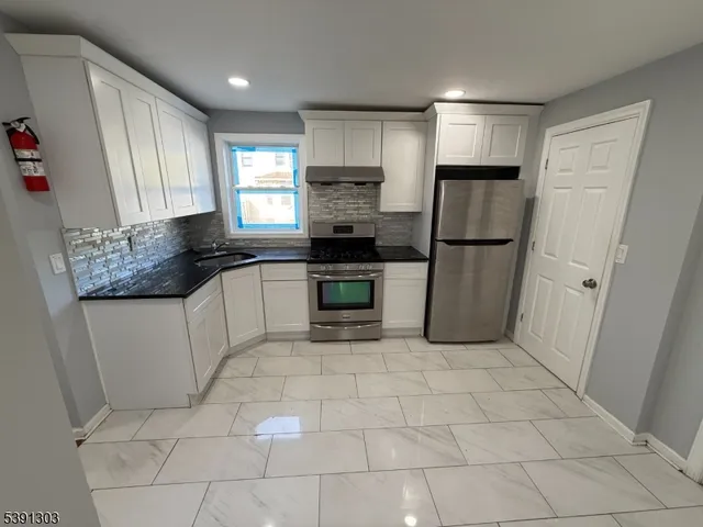 a kitchen with a stove a refrigerator and a sink
