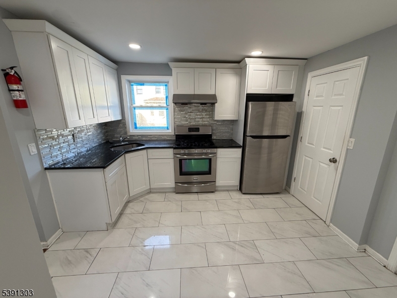 a kitchen with a stove a refrigerator and a sink