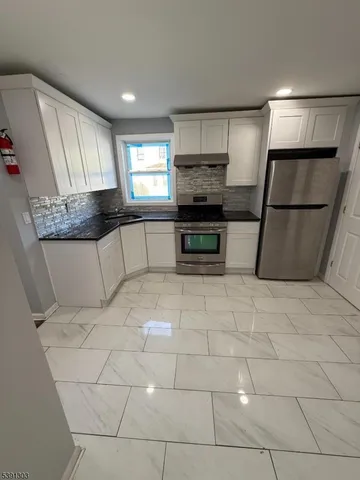 a kitchen with stainless steel appliances a refrigerator sink and microwave