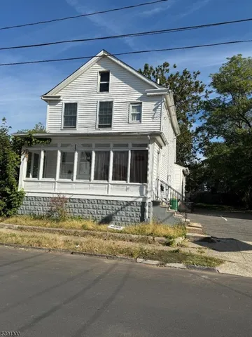 a front view of a house with a garden and mountain view