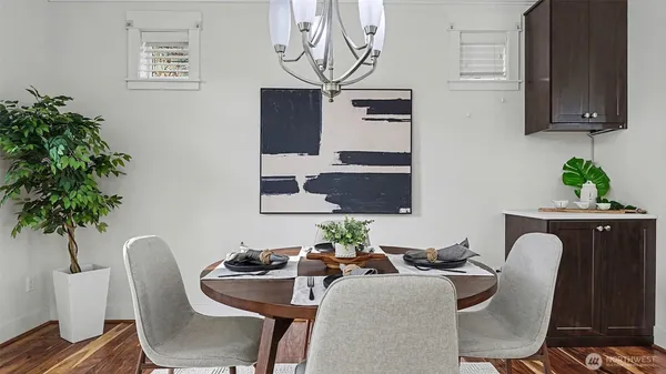 a dining room with furniture a potted plant and a window