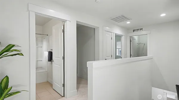 a view of hallway with bathroom and a shower