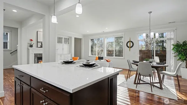 a view of a dining room and livingroom with furniture wooden floor a chandelier