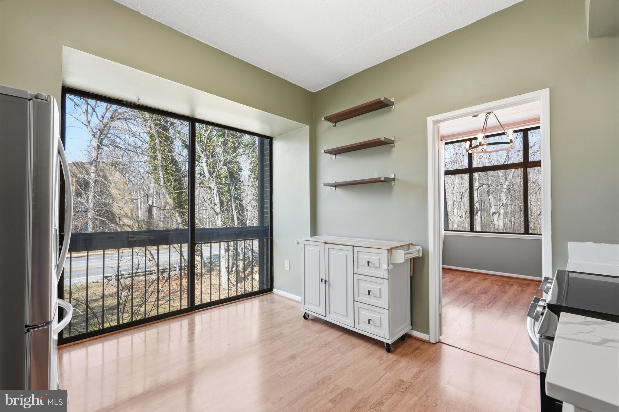 11566 Rolling Green Court, Unit 12/200A Reston, VA 20191 - Photo 11 of 25 a view of a kitchen with an empty room and wooden floor