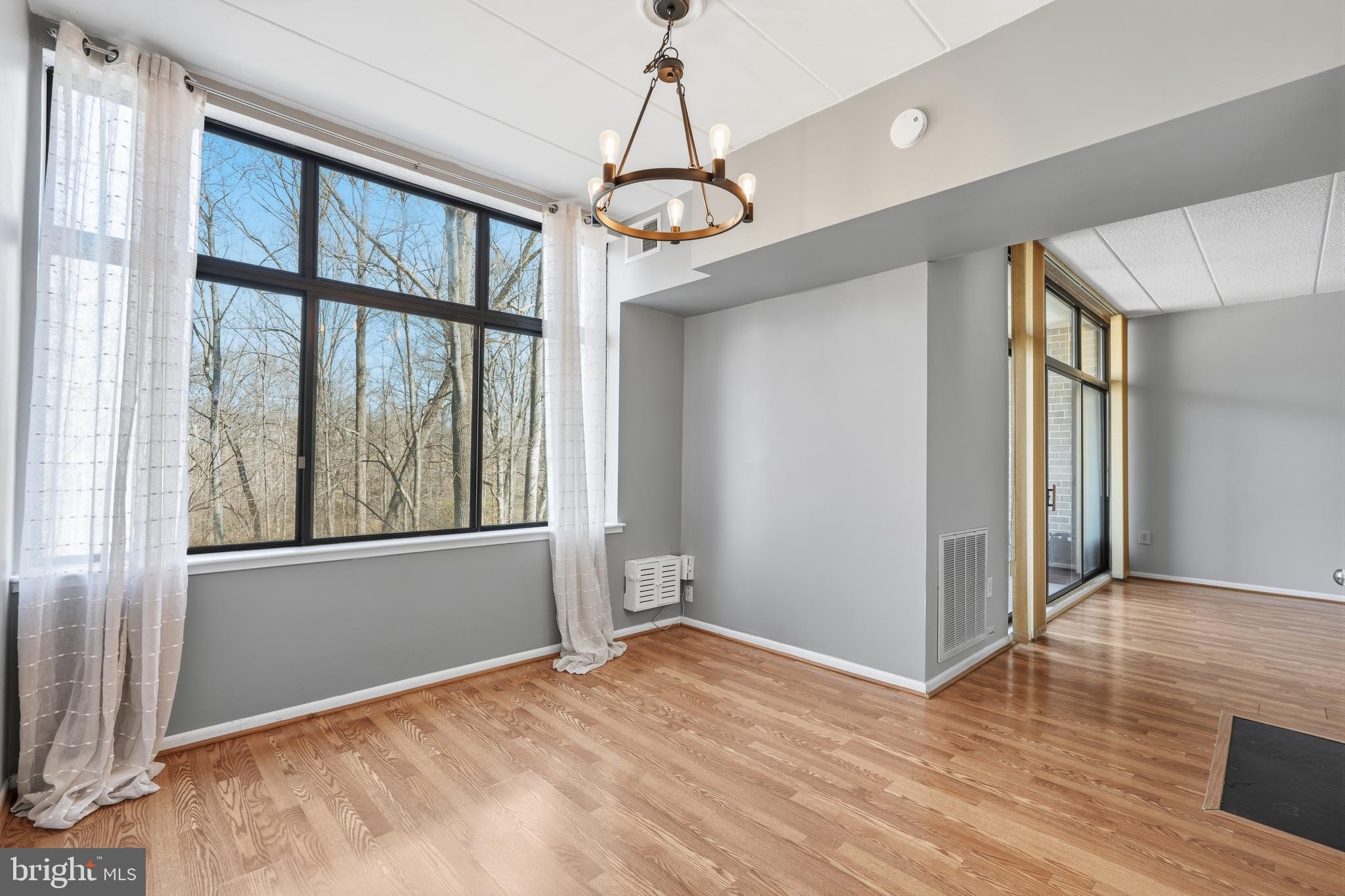 11566 Rolling Green Court, Unit 12/200A Reston, VA 20191 - Photo 6 of 25 an empty room with wooden floor and windows
