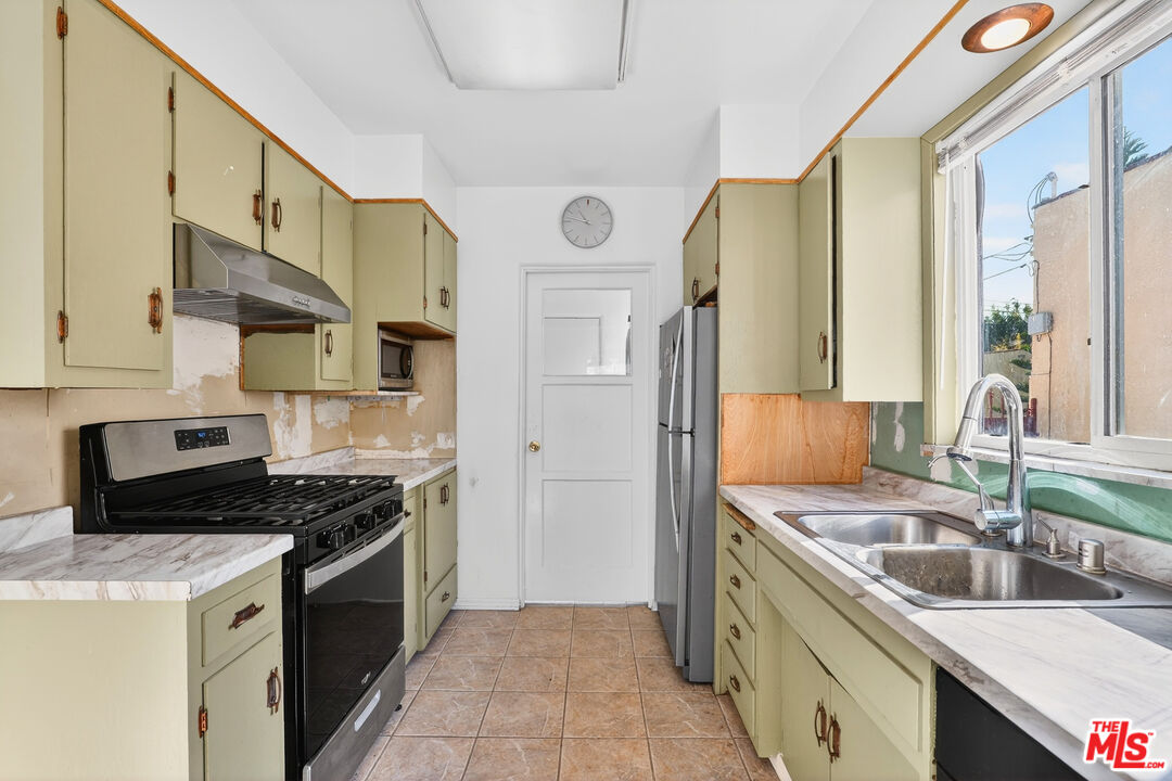 1544 South Point View Street Los Angeles, CA 90035 - Photo 24 of 67 a kitchen with stainless steel appliances granite countertop a sink stove and refrigerator