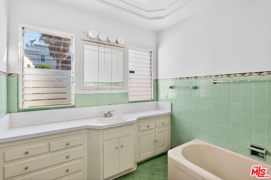 1544 South Point View Street Los Angeles, CA 90035 - Photo 32 of 67 a bathroom with a sink a bathtub a mirror a vanity and a bathtub