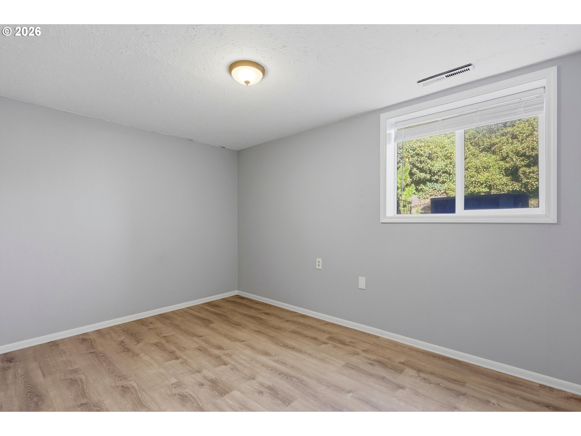 1829 East 8th Street The Dalles, OR 97058 - Photo 25 of 48 a view of an empty room with wooden floor and windows
