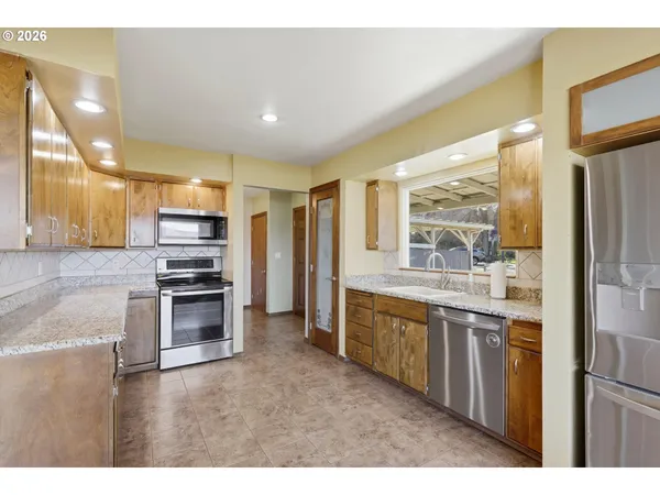 a kitchen with kitchen island granite countertop a stove and a sink
