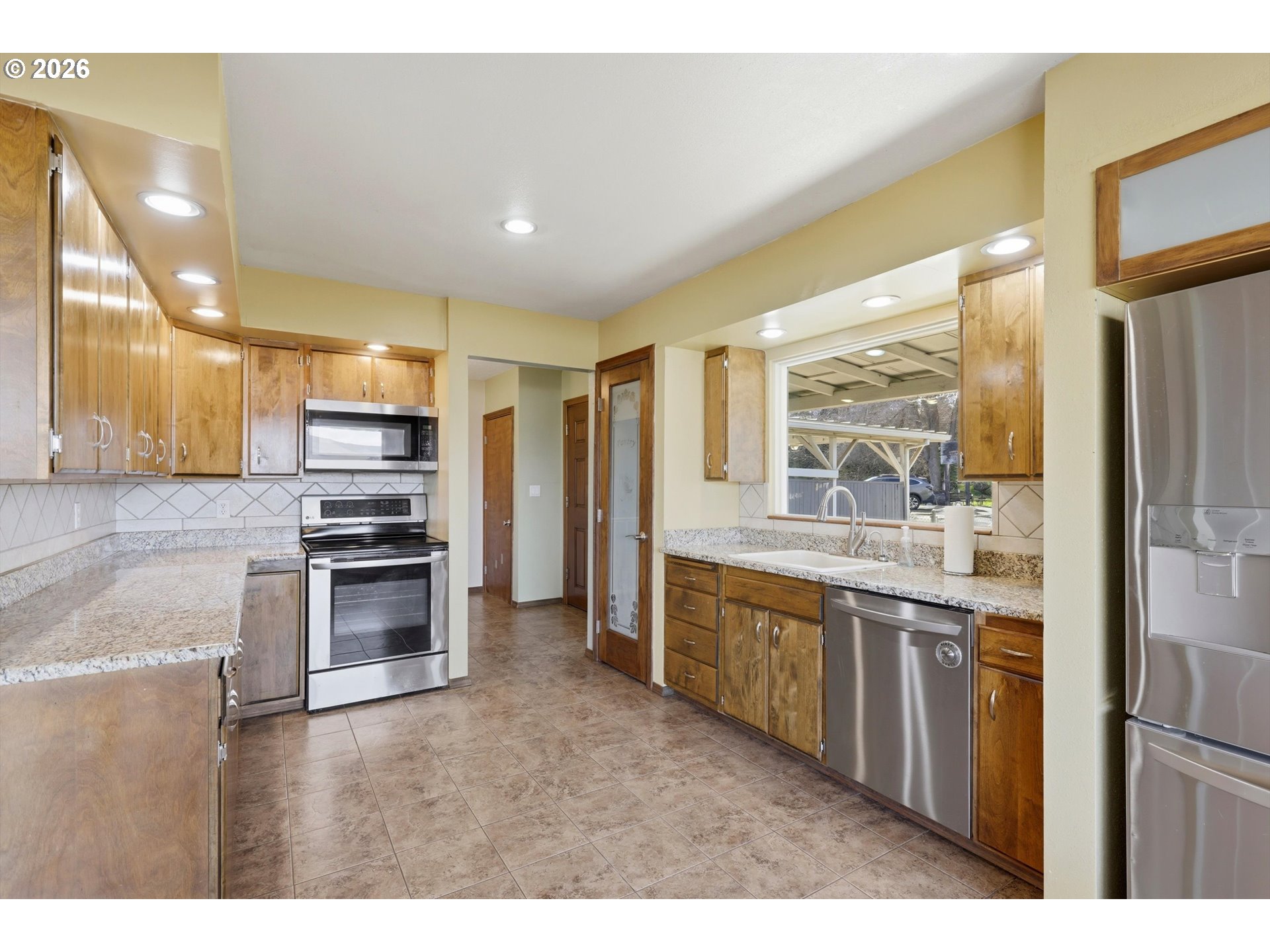 1829 East 8th Street The Dalles, OR 97058 - Photo 8 of 48 a large kitchen with stainless steel appliances kitchen island granite countertop a large kitchen island a stove a refrigerator a sink and dishwasher