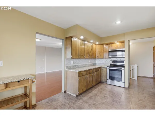 a kitchen with stainless steel appliances granite countertop a refrigerator and a stove top oven