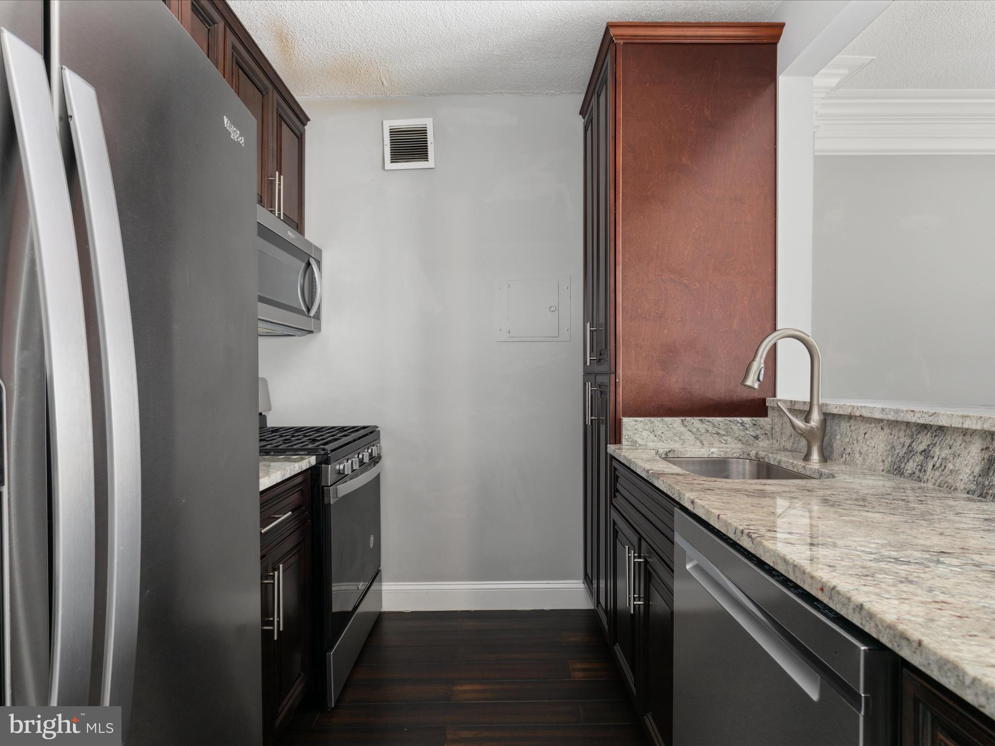 4141 North Henderson Road, Unit 809 Arlington, VA 22203 - Photo 7 of 21 a kitchen with stainless steel appliances granite countertop a sink stove and refrigerator