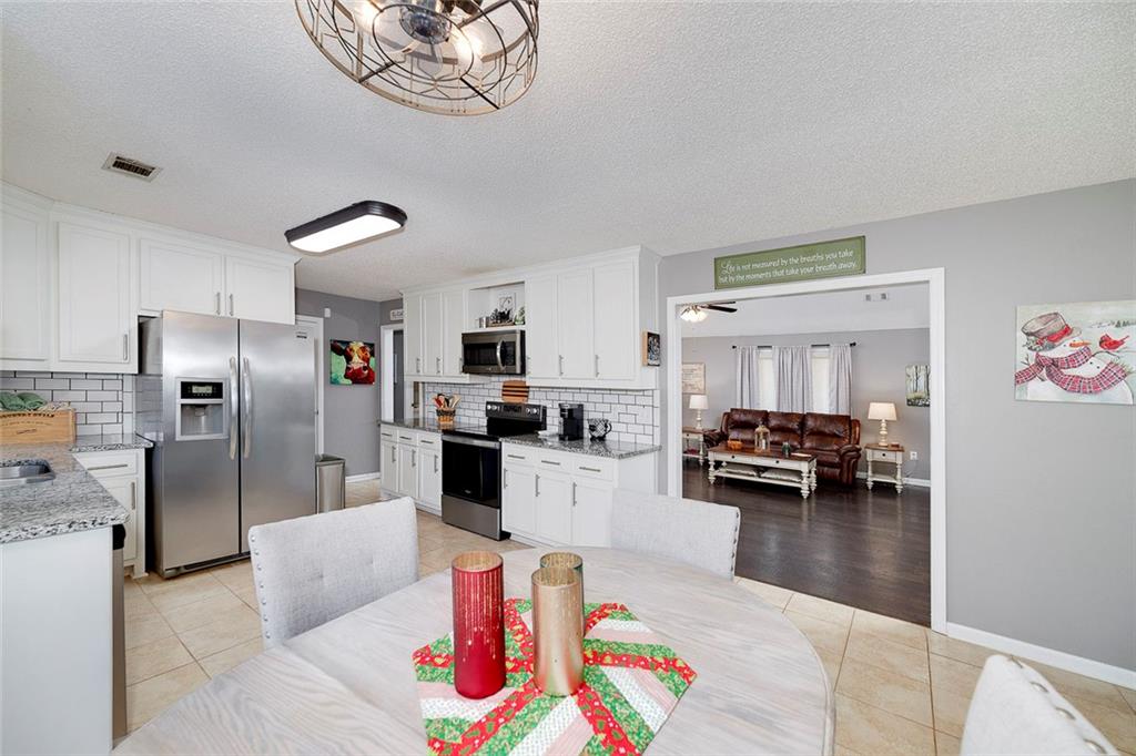 121 Harper Road McDonough, GA 30252 - Photo 16 of 38 a kitchen with stainless steel appliances kitchen island granite countertop a refrigerator and stove