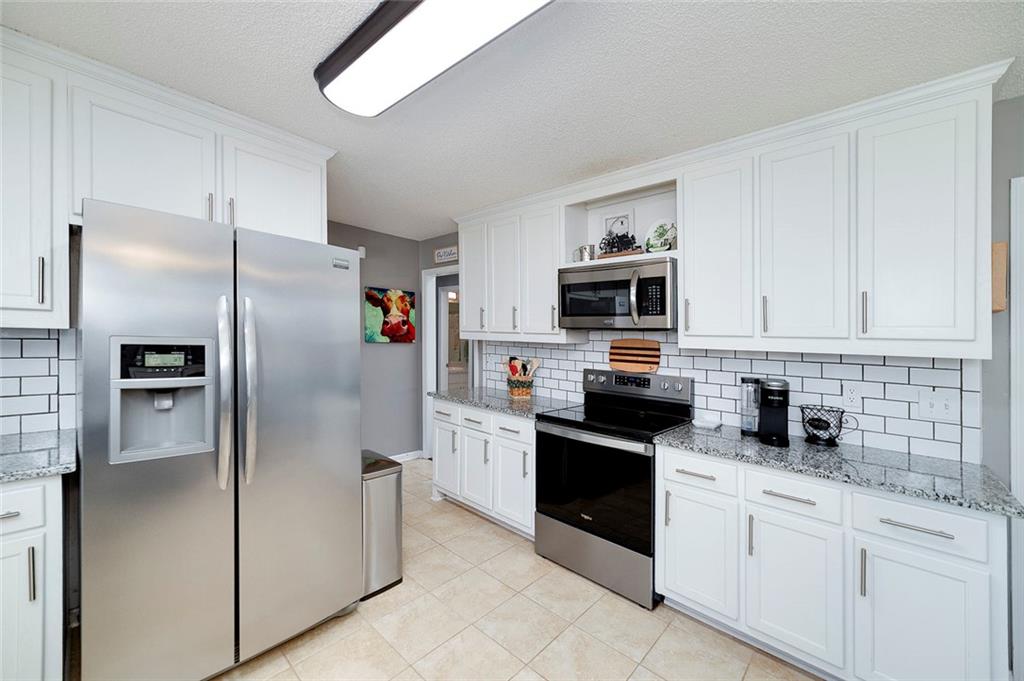 121 Harper Road McDonough, GA 30252 - Photo 18 of 38 a kitchen with stainless steel appliances granite countertop a refrigerator stove and microwave