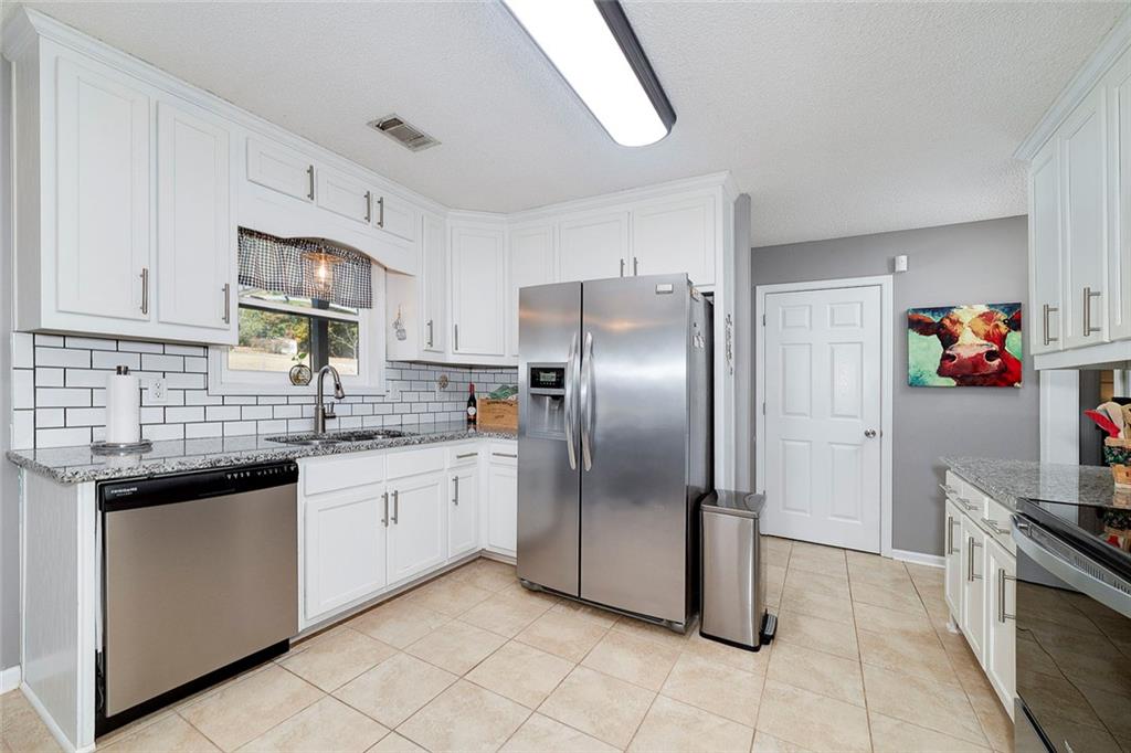 121 Harper Road McDonough, GA 30252 - Photo 19 of 38 a kitchen with stainless steel appliances granite countertop a refrigerator and a sink