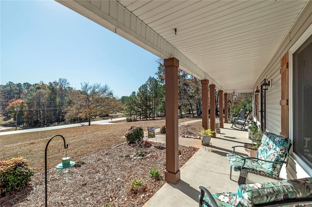 121 Harper Road McDonough, GA 30252 - Photo 10 of 38 a view of a patio with a dining table and chairs with wooden floor and fence