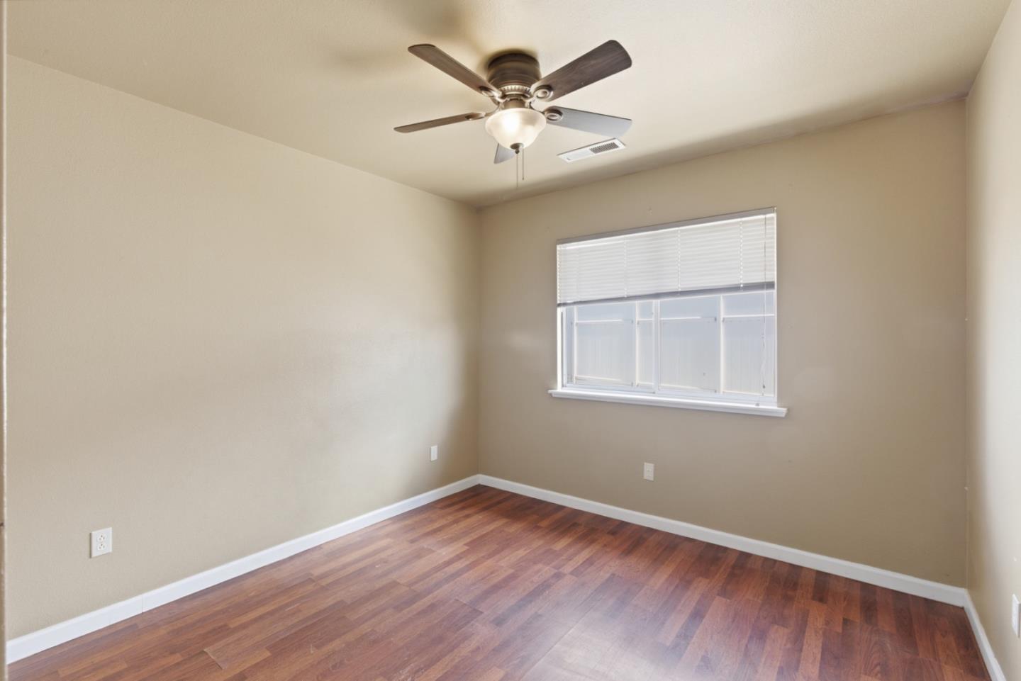 449 Sage Court Soledad, CA 93960 - Photo 11 of 17 an empty room with wooden floor and windows