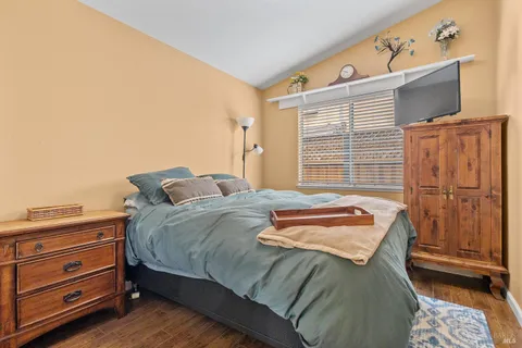 a bedroom with a bed and a flat tv screen on dresser
