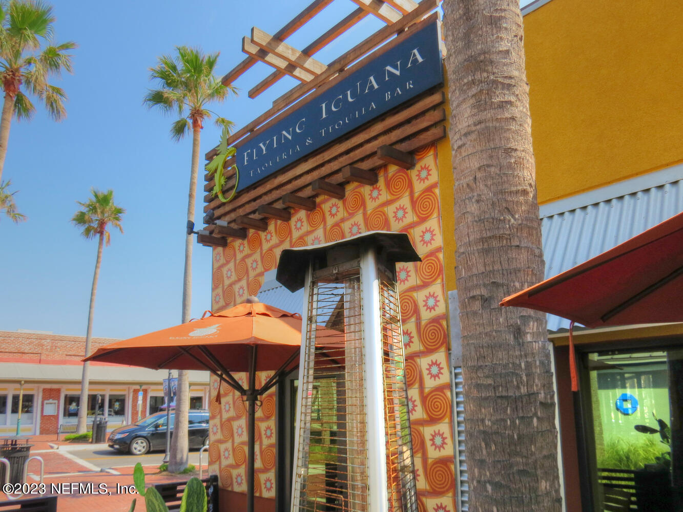 962 Ocean Boulevard Atlantic Beach, FL 32233 - Photo 57 of 63 a view of a cafe with a table and chairs under an umbrella