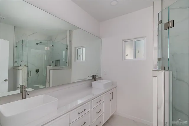 a bathroom with a sink shower and a mirror