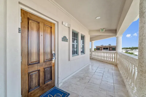 a view of a hallway with wooden floor and a kitchen