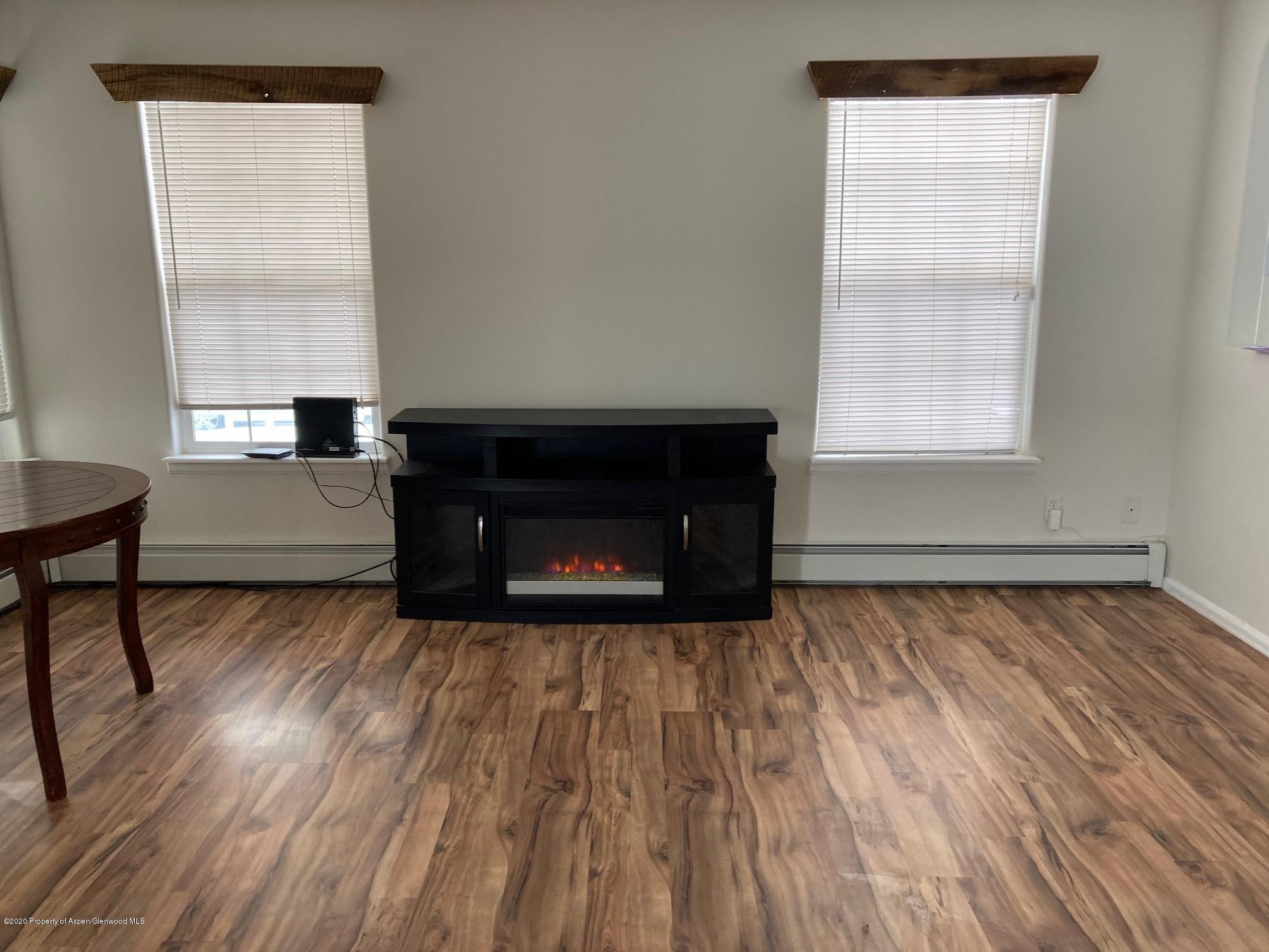 401 Evergreen Drive Rifle, CO 81650 - Photo 3 of 18 a living room with a fireplace wooden floor and a window