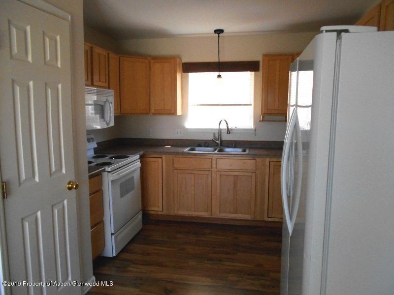 401 Evergreen Drive Rifle, CO 81650 - Photo 5 of 18 a kitchen with stainless steel appliances granite countertop a sink stove and refrigerator