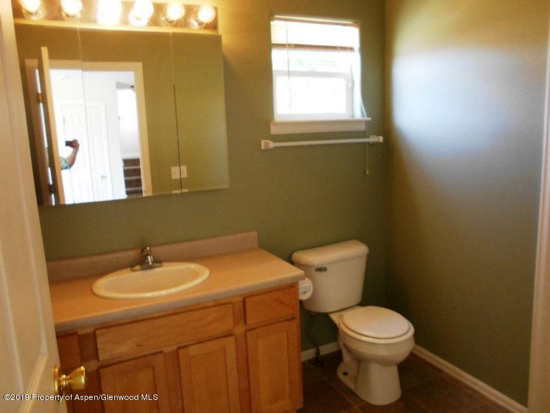 401 Evergreen Drive Rifle, CO 81650 - Photo 7 of 18 a white toilet sitting next to a bathroom sink