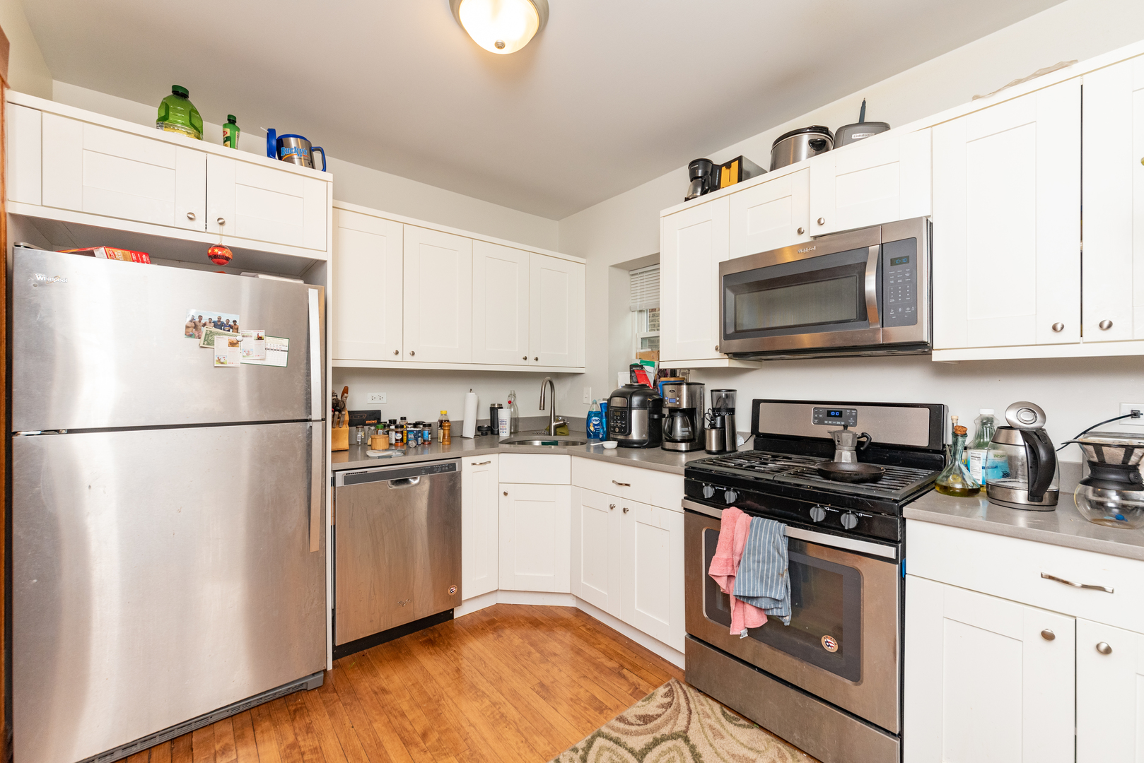3716 North Racine Avenue, Unit 2 Chicago, IL 60613 - Photo 8 of 14 a kitchen with stainless steel appliances granite countertop a refrigerator stove a sink dishwasher and microwave with cabinets
