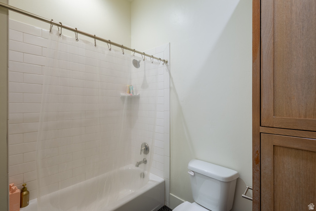 630 East Center Street Alpine, UT 84004 - Photo 59 of 115 Bathroom featuring a white subway tile surround, a built-in tub, polished chrome fixtures, a white toilet, and wood-finish cabinetry