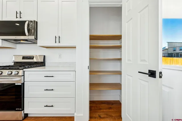 a view of a kitchen with white cabinets and a stove