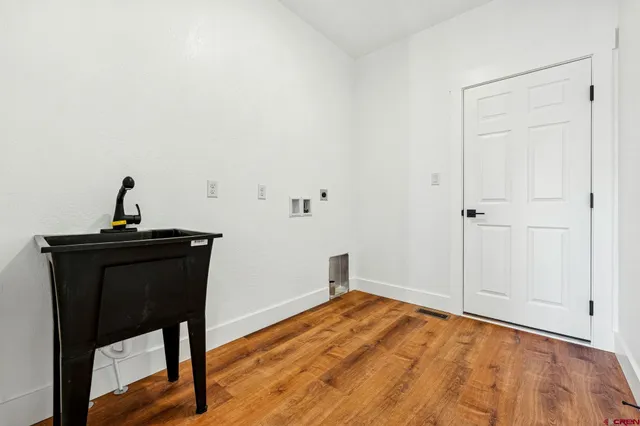 a view of a livingroom with wooden floor and a sink