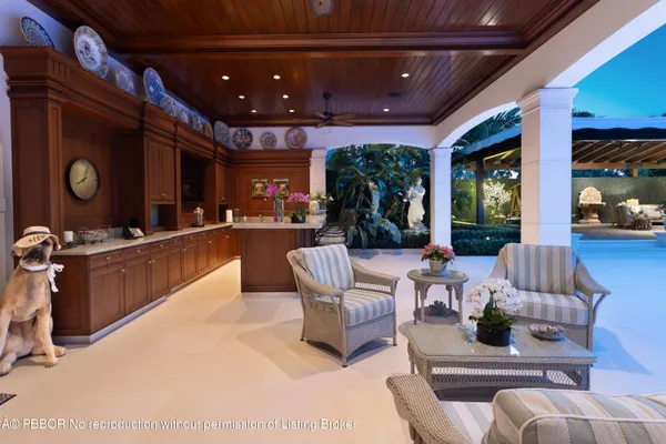 a living room with furniture a floor to ceiling window and potted plants
