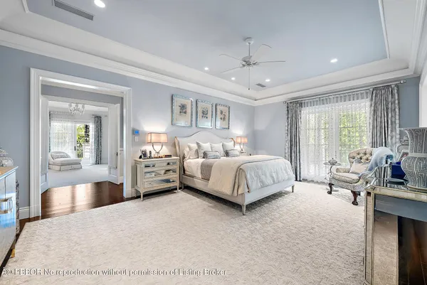 a spacious en suite bathroom with a granite countertop tub a sink and a large mirror