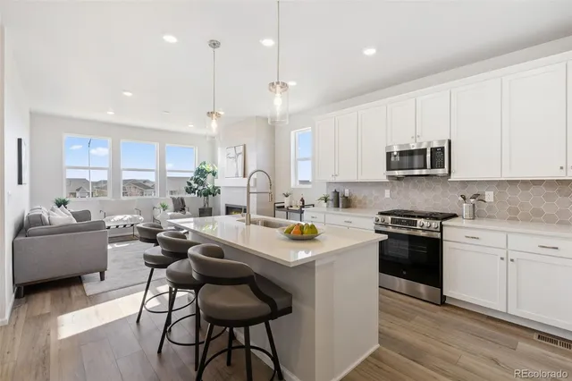 a kitchen with a sink stove a microwave and cabinets