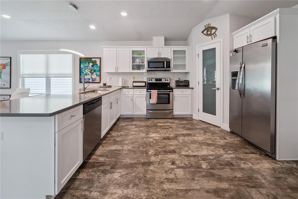 1790 Southwest 247th Street Newberry, FL 32669 - Photo 16 of 44 a large kitchen with stainless steel appliances granite countertop a refrigerator a stove a sink and a microwave