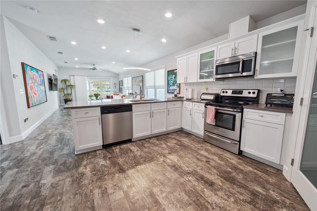 1790 Southwest 247th Street Newberry, FL 32669 - Photo 17 of 44 a kitchen with stainless steel appliances granite countertop a stove top oven a sink dishwasher and a refrigerator