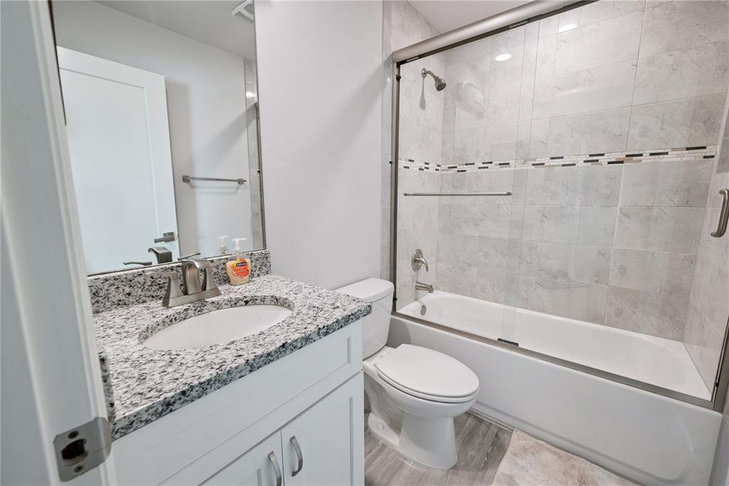 1790 Southwest 247th Street Newberry, FL 32669 - Photo 25 of 44 a bathroom with a granite countertop sink toilet mirror and shower