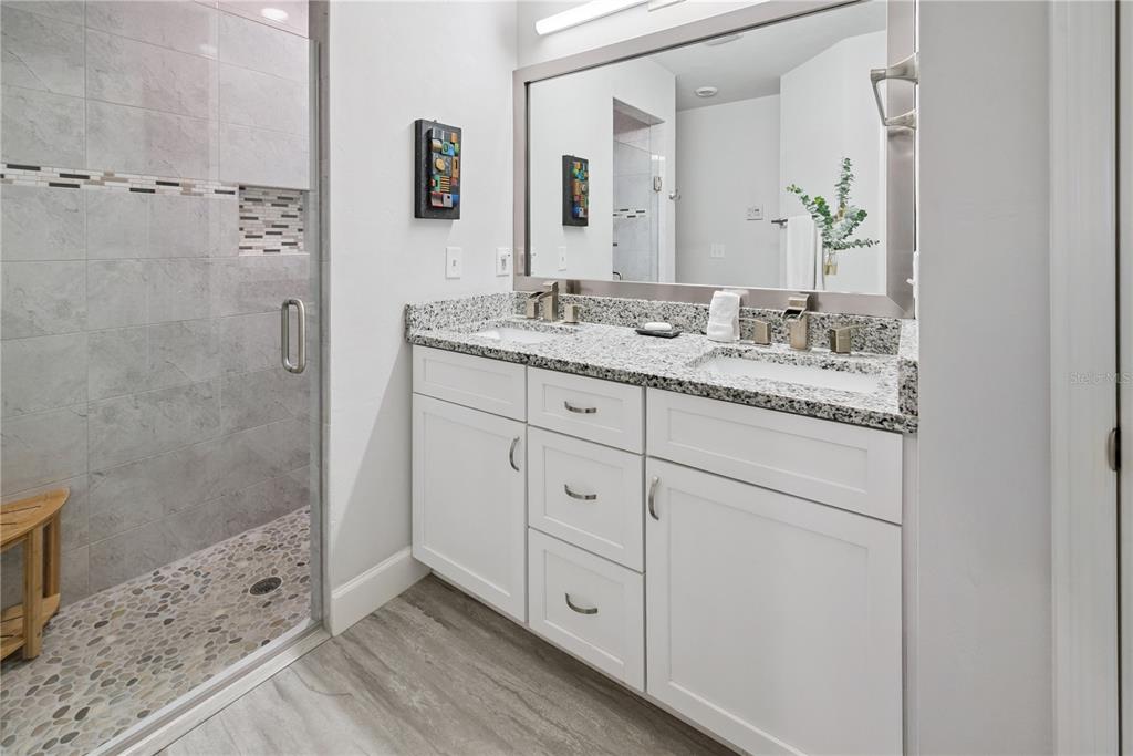 1790 Southwest 247th Street Newberry, FL 32669 - Photo 30 of 44 a bathroom with a granite countertop sink a mirror and a shower
