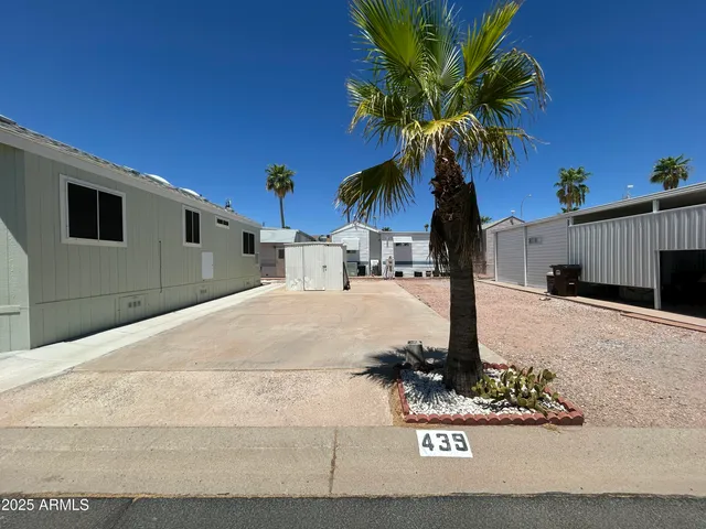 a vase of flowers sitting on a sidewalk
