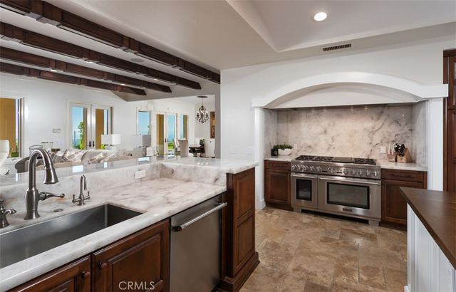 a kitchen with stainless steel appliances granite countertop a sink and a refrigerator