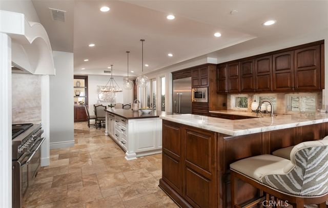 a kitchen with stainless steel appliances granite countertop a sink a stove and a refrigerator