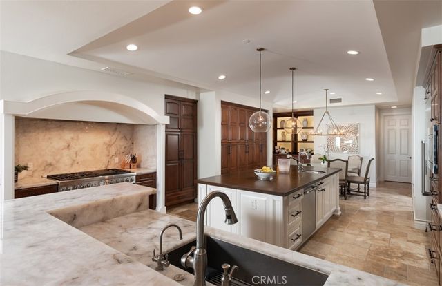 a kitchen with stainless steel appliances granite countertop a sink a stove and a refrigerator