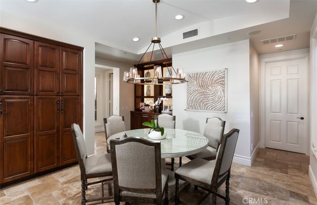 a view of a dining room with furniture one side kitchen view and wooden floor