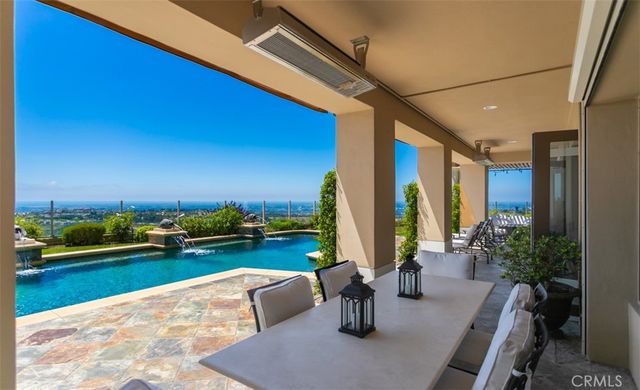 a view of a swimming pool with lawn chairs under an umbrella