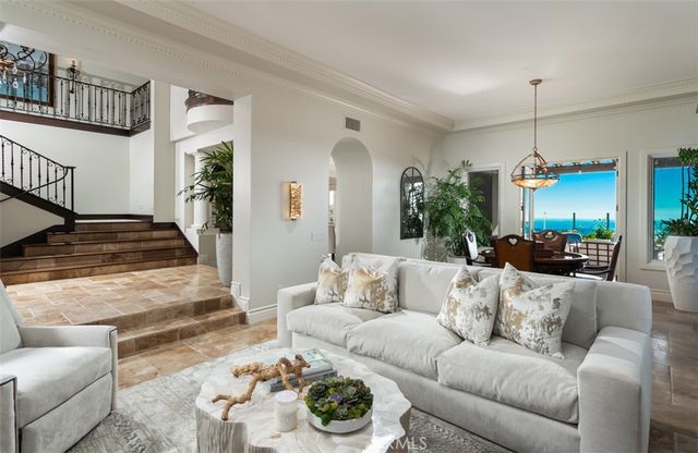a living room with furniture kitchen view and a large window