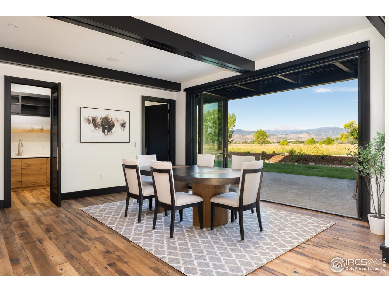 12357 North 75th Street Longmont, CO 80503 - Photo 19 of 49 a dining room with furniture a floor to ceiling window and wooden floor